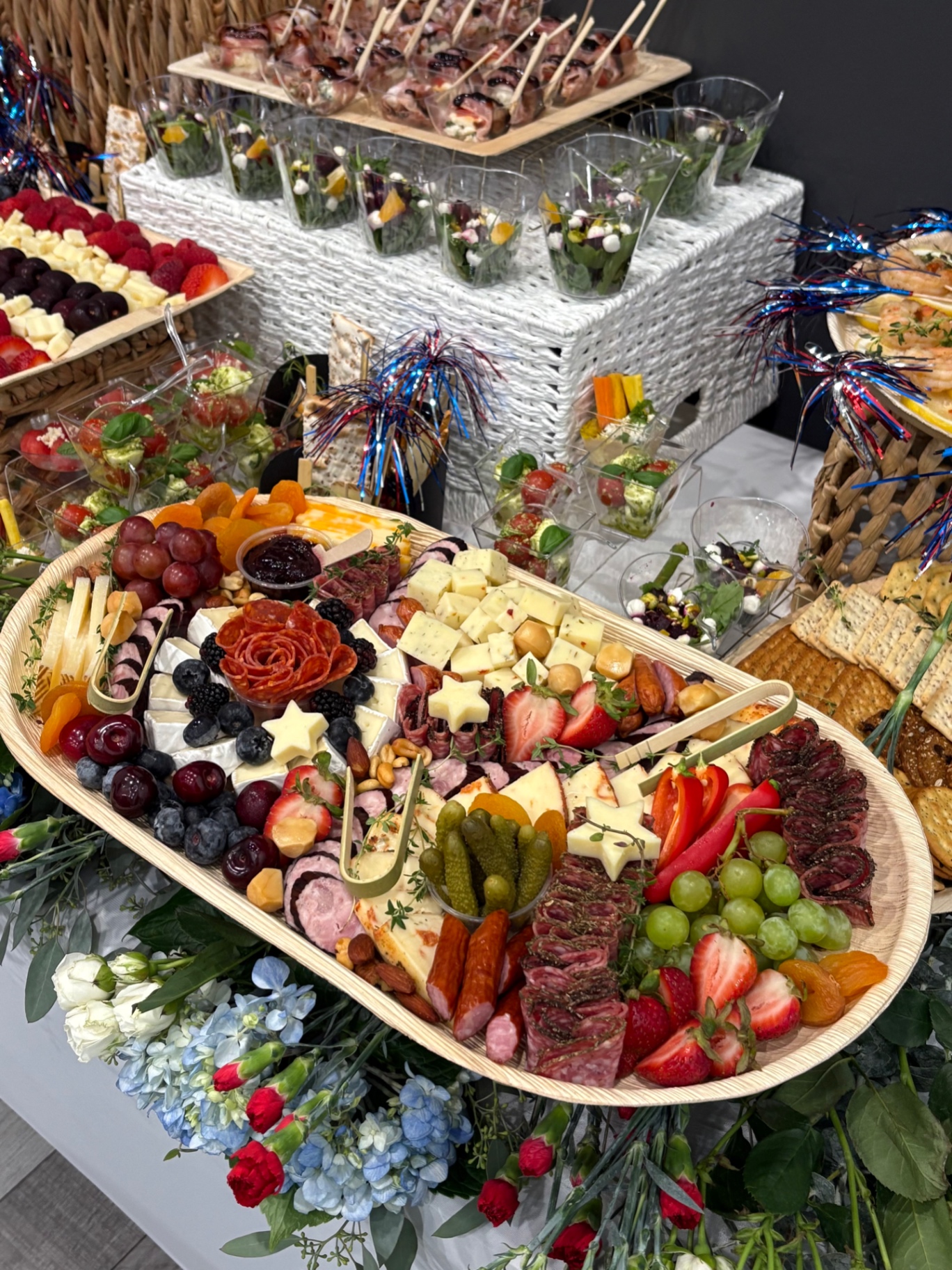Corporate event grazing platter with star-shaped cheese cutouts, a pepperoni rose, berries, and festive picks